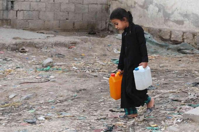 Ένα μικρό κορίτσι μεταφέρει μπιτόνια γεμάτα με καθαρό νερό από μια φιλανθρωπική αντλία κατά τη διάρκεια μιας συνεχιζόμενης κρίσης καθαρού νερού στην Υεμένη