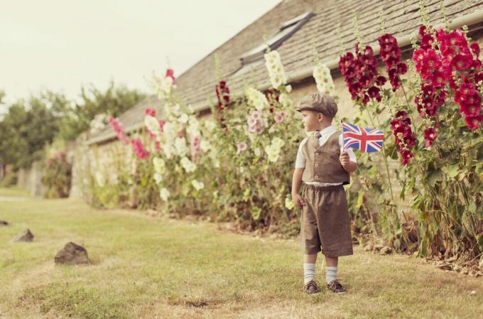 Vintage βρετανικό αγόρι που στέκεται με το Union Jack