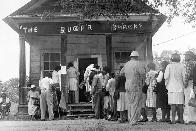 Αφροαμερικανοί ψηφοφόροι, που μπορούν να ψηφίσουν για πρώτη φορά στην επαρχία Wilcox County της Αλαμπάμα, παρατάσσονται μπροστά από ένα εκλογικό τμήμα μετά την ψήφιση του ομοσπονδιακού νόμου για τα δικαιώματα ψήφου το 1965.