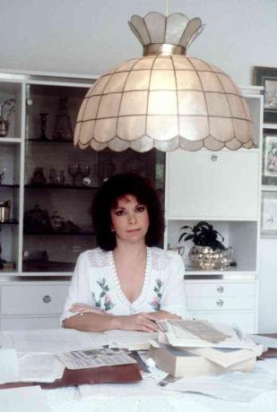 Η Isabel Allende σε ένα γραφείο που καλύπτεται από χαρτιά